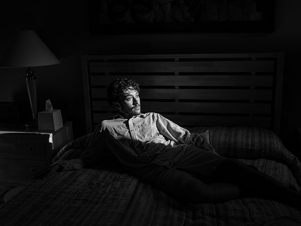 Young man sitting in the dark