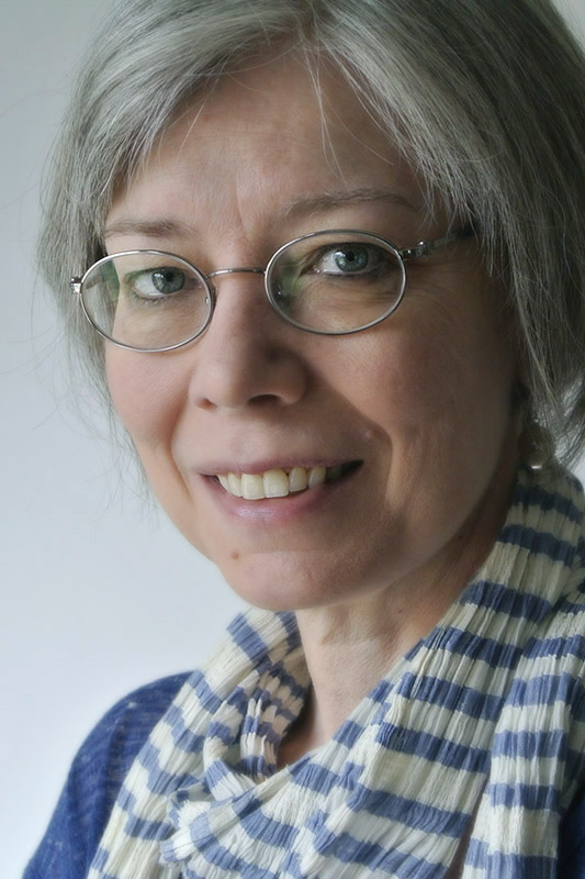 Photograph of woman with glasses checkered scarf.