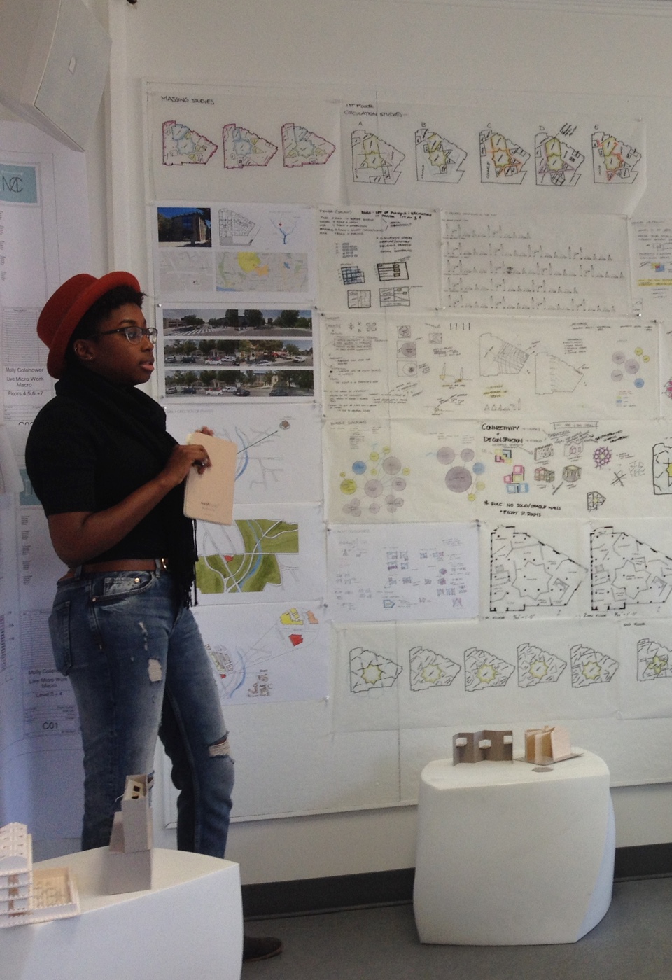 Female student standing with architectural drawings