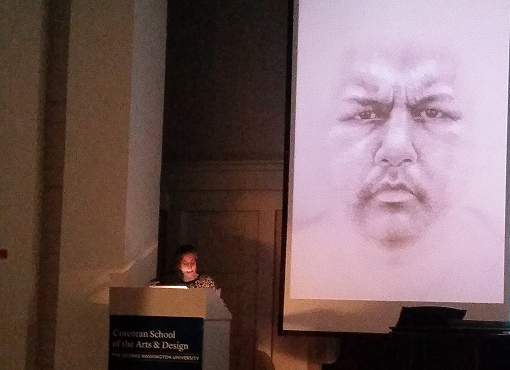 Lynn Sures speaks about an aboriginal face drawing next to her