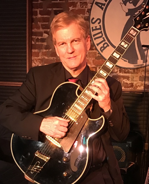 Photo of John Albertson with guitar