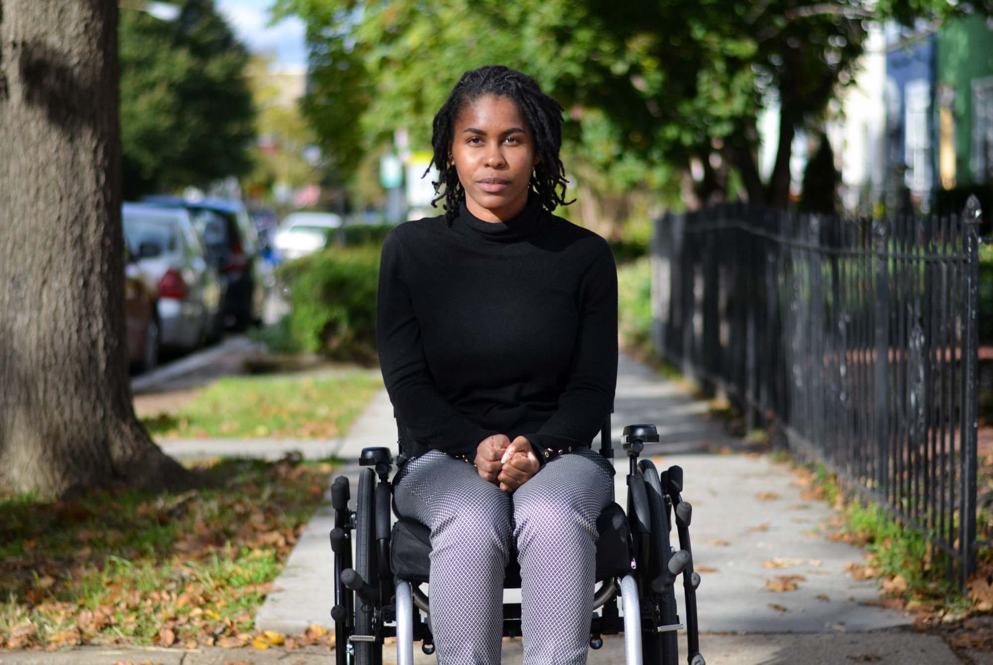 Alumna Tyree Brown sitting in her wheelchair on the sidewalk.