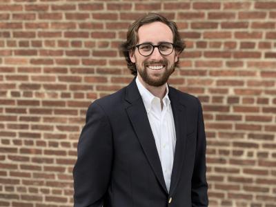 Photo of Douglas Crawford standing in front of a brick wall