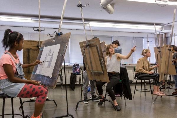 Students sit are drawing easles workng on projects