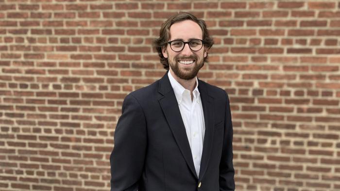Photo of Douglas Crawford standing in front of a brick wall