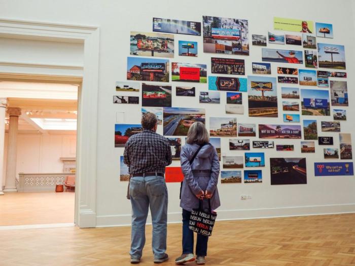 Visitors look at the Billboards exhibit installed in the Corcoran Gallery of Art as part of the For Freedoms residency.