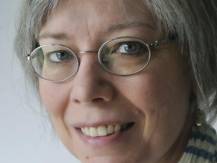 Photograph of woman with glasses checkered scarf.