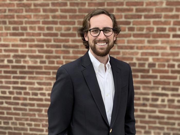 Photo of Douglas Crawford standing in front of a brick wall